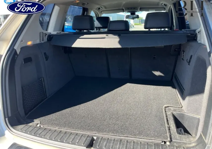 Coffre ouvert vu de l'arrière d'un BMW X3 Mineralsilber 2013, avec cache-bagages et banquette arrière visible.