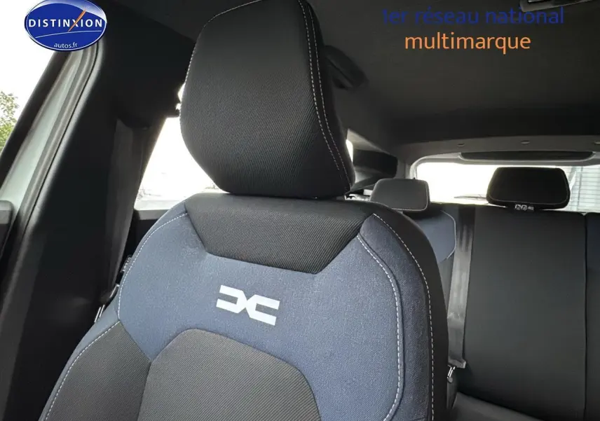 Gros plan sur le siège avant conducteur bleu et noir avec logo DACIA, intérieur du Dacia Duster 2025.