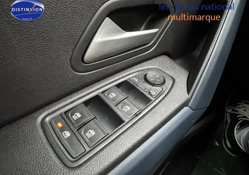Gros plan sur les commandes des vitres électriques côté conducteur du Dacia Duster 2025 avec bouton de verrouillage activé.