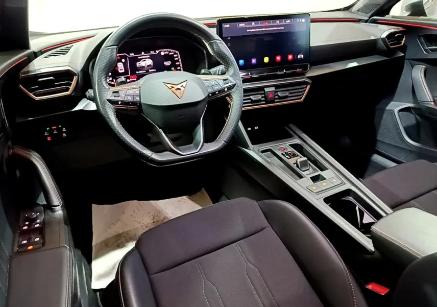 Vue intérieure avant du CUPRA Formentor 1.5 TSI 2024, volant cuir alu multifonctions et grand écran tactile central.