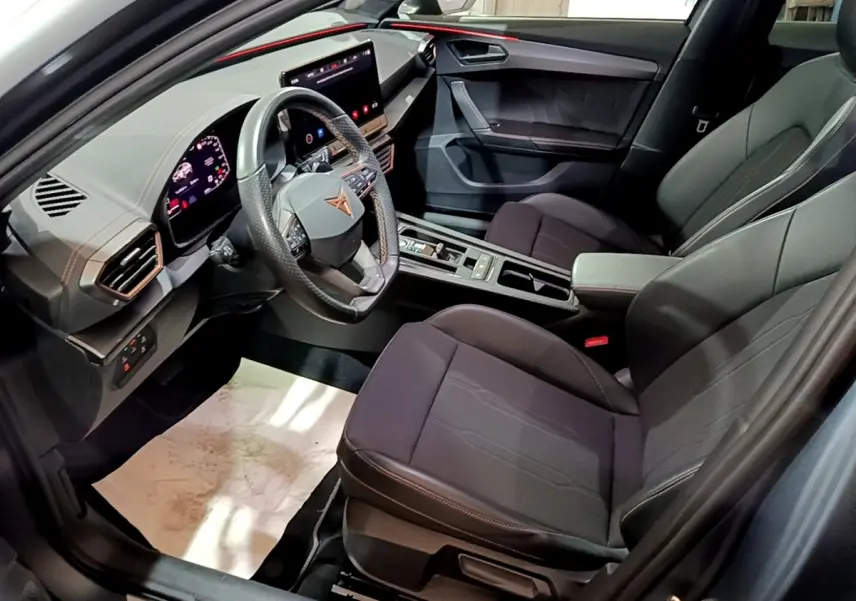 Vue intérieure côté conducteur du CUPRA Formentor 2024 gris foncé, volant multifonctions cuir alu et écran tactile central.