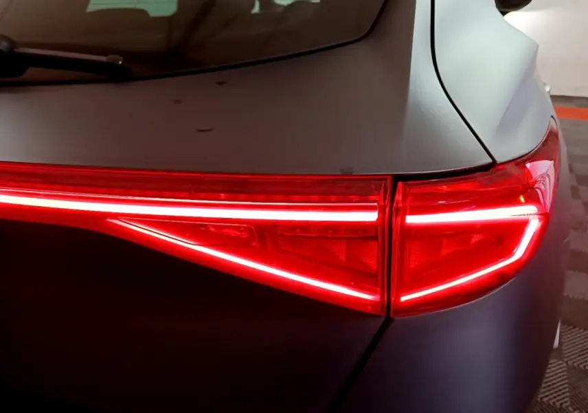 Gros plan sur le feu arrière droit rouge allumé du CUPRA Formentor gris foncé, soulignant la ligne lumineuse fine.