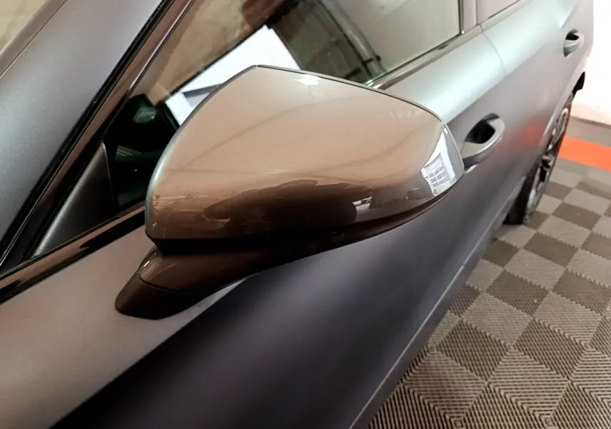Gros plan sur le rétroviseur droit gris foncé du CUPRA Formentor 2024, avec partie de la porte visible en arrière-plan.