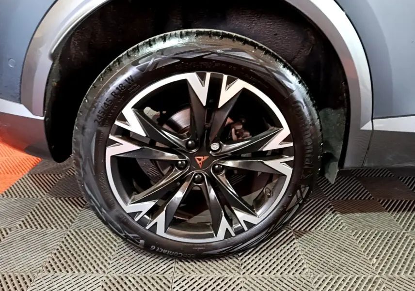 Gros plan sur la roue avant droite du CUPRA Formentor gris foncé avec jante alliage noire et argentée au design anguleux.