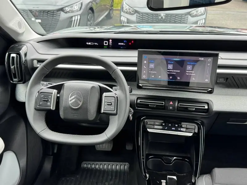 Vue intérieure de face du tableau de bord et volant noir de la Citroën C3 électrique 2025 avec écran tactile central.