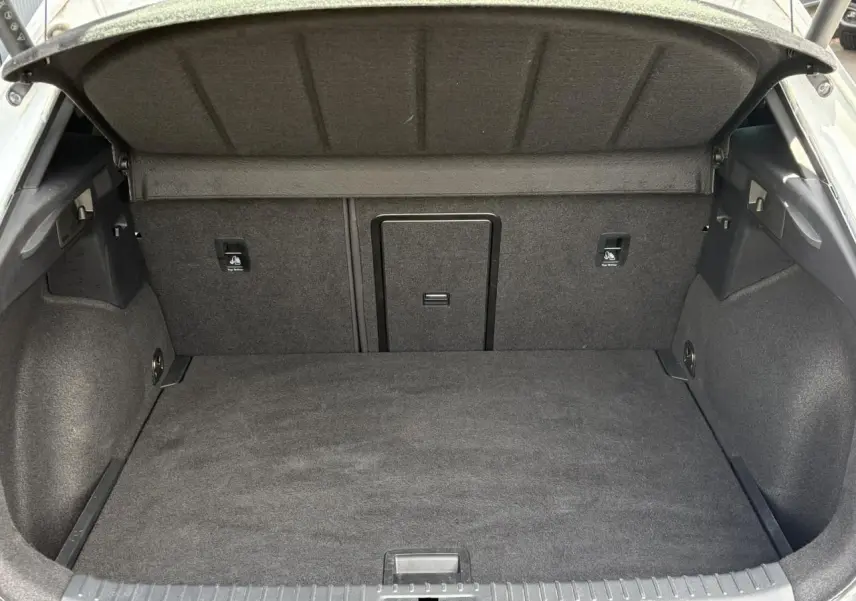 Coffre ouvert vu de l'arrière d'une CUPRA Formentor blanc Neige, intérieur de coffre en tissu gris foncé.