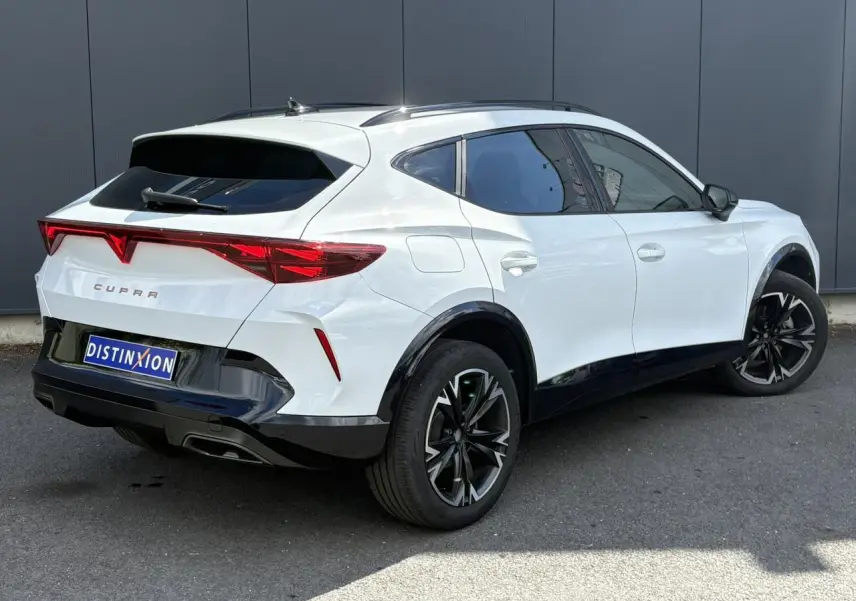 Vue 3/4 arrière droite d'un CUPRA Formentor blanc Neige avec jantes alliage noires et toit noir contrasté.
