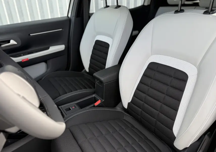 Vue intérieure rapprochée des sièges avant bi-ton noir et blanc du Citroën C3 Aircross Hybrid 145 e-DSC6 Max 2026.