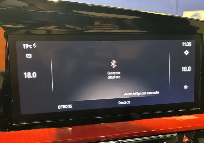 Écran tactile central de l’Opel Mokka GS Line 2022 affichant la connexion Bluetooth, entouré d’un tableau de bord rouge brillant.
