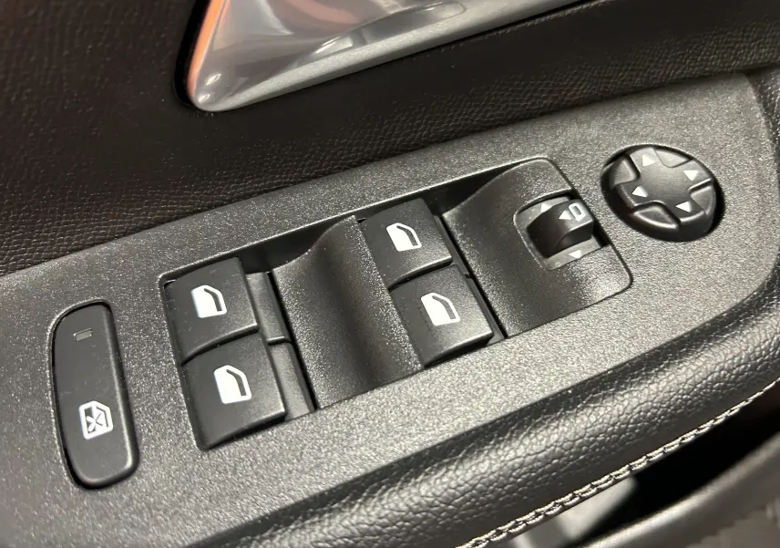 Gros plan sur les commandes des vitres électriques et réglage des rétroviseurs côté conducteur d’un Opel Mokka GS Line 2022.