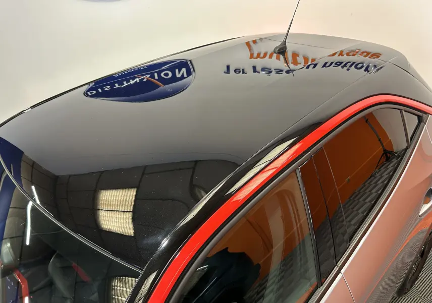 Vue en plongée du toit noir brillant avec antenne et contour rouge vif sur Opel Mokka gris, côté droit.