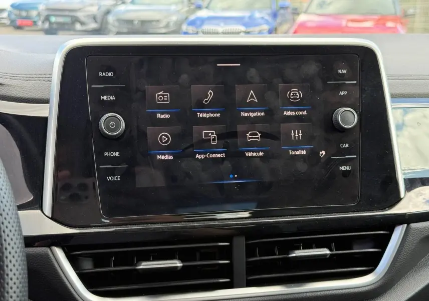 Écran tactile central du tableau de bord du Volkswagen T-Roc, avec menu multimédia affiché, intérieur noir.