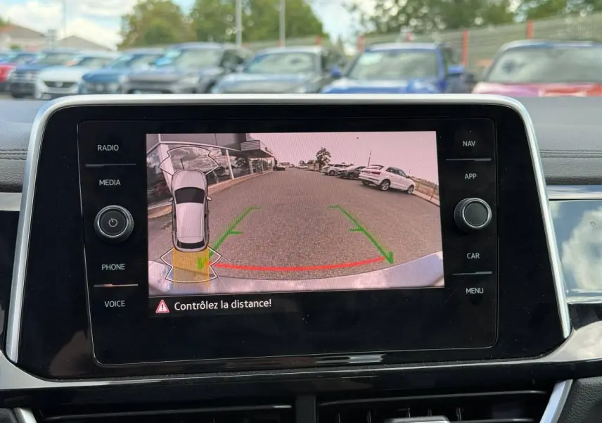 Écran tactile intérieur montrant la caméra de recul avec vue arrière et lignes de guidage vertes et rouges.