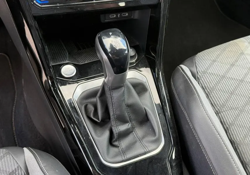Le levier de vitesse automatique noir et gris du Volkswagen T-Roc 2025, avec sellerie tissu et cuir gris visible.