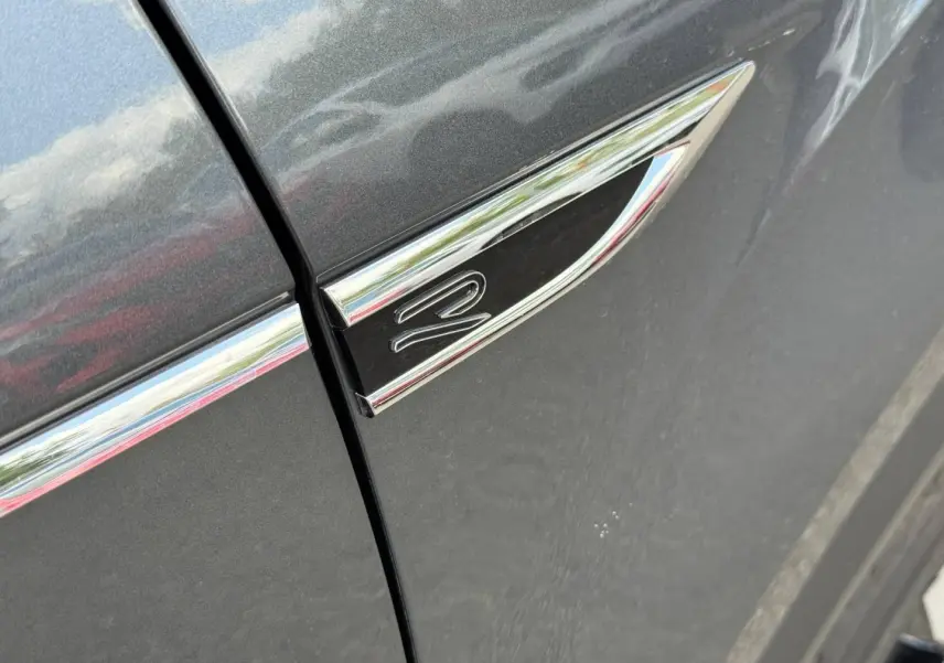 Détail de l’aile avant gauche gris Indium métallisé avec monogramme R-Line chromé et baguette décorative.