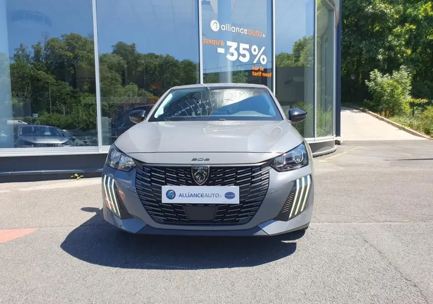 Peugeot 208 gris Sellenium vue de face, mettant en valeur la calandre noire et les feux diurnes LED en griffes.