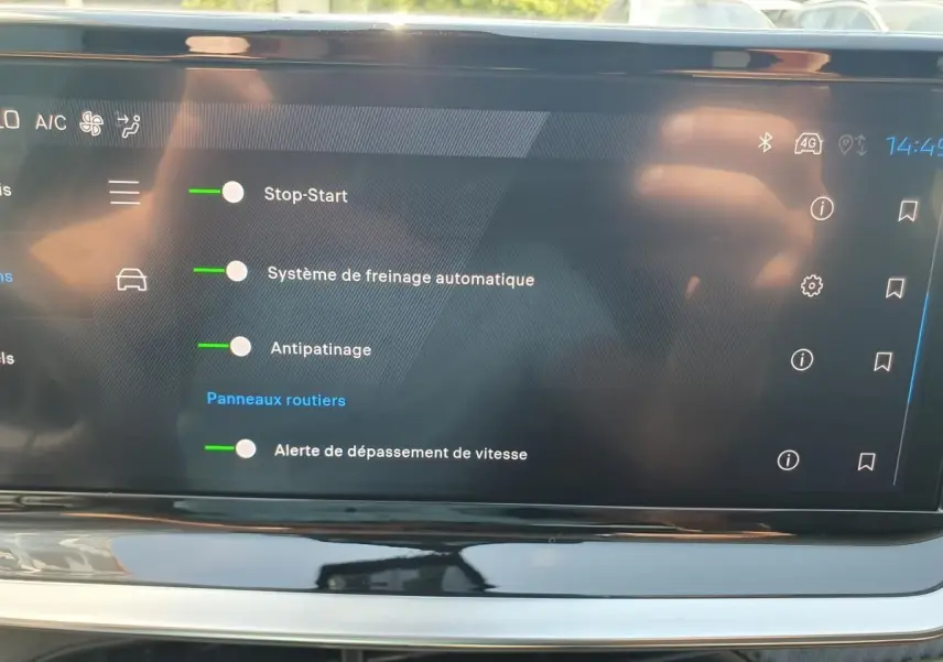 Écran tactile intérieur de la Peugeot 208 1.2 Hybrid 110 Allure affichant les options d’aide à la conduite activées.