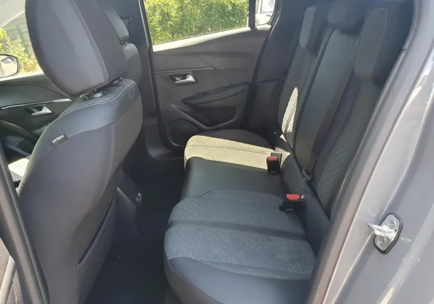 Vue intérieure côté droit sur la banquette arrière en tissu et cuir noir de la Peugeot 208 gris Sellenium 2025.