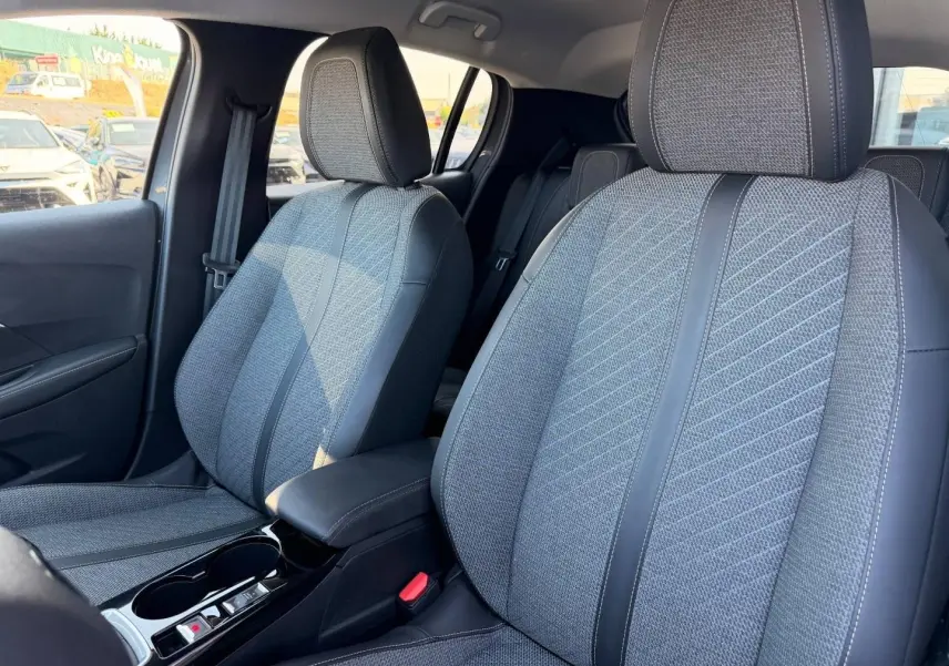 Vue intérieure rapprochée des sièges avant gris tissu et simili cuir de la Peugeot 208 1.2 100ch Allure.