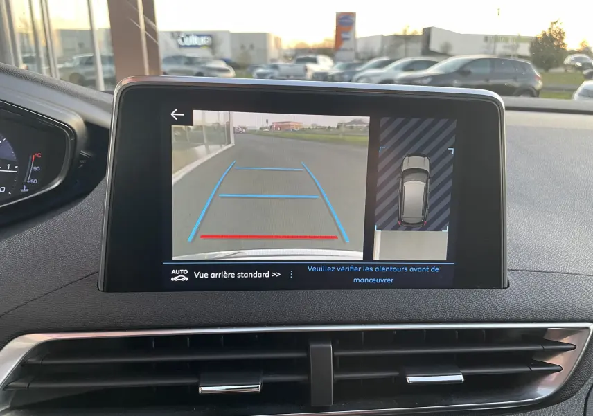 Écran central du Peugeot 3008 blanc nacré 2019 montrant la caméra de recul avec guidage de trajectoire bleu et rouge.