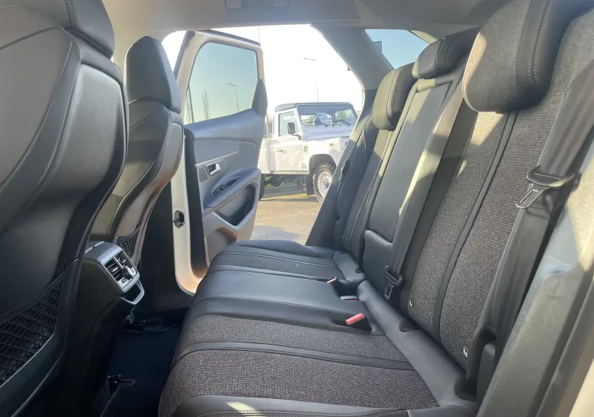 Vue intérieure côté droit des sièges arrière gris noir du Peugeot 3008 blanc nacré avec porte arrière ouverte.