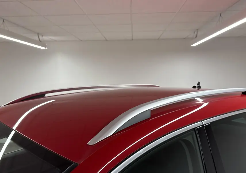 Toit rouge velvet du SEAT Ateca 2024 avec barres de toit argentées, vu en gros plan côté droit.