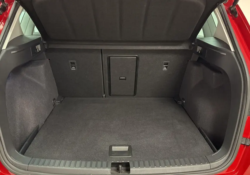 Coffre ouvert d'un SEAT Ateca Rouge Velvet 2024, montrant le plancher à double fond et l'espace de chargement.