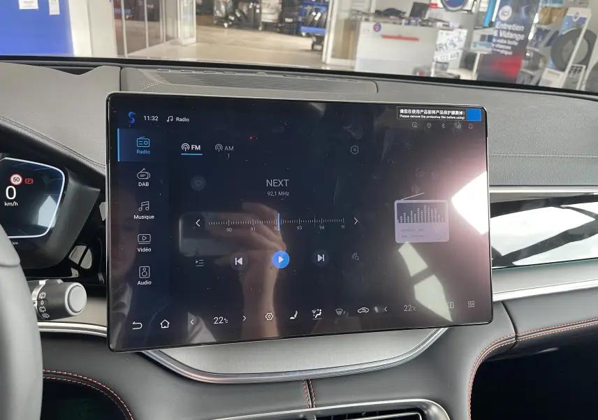 Écran tactile central 15,6'' du tableau de bord du BYD SEAL U 2026, avec interface radio et commandes climatiques visibles.