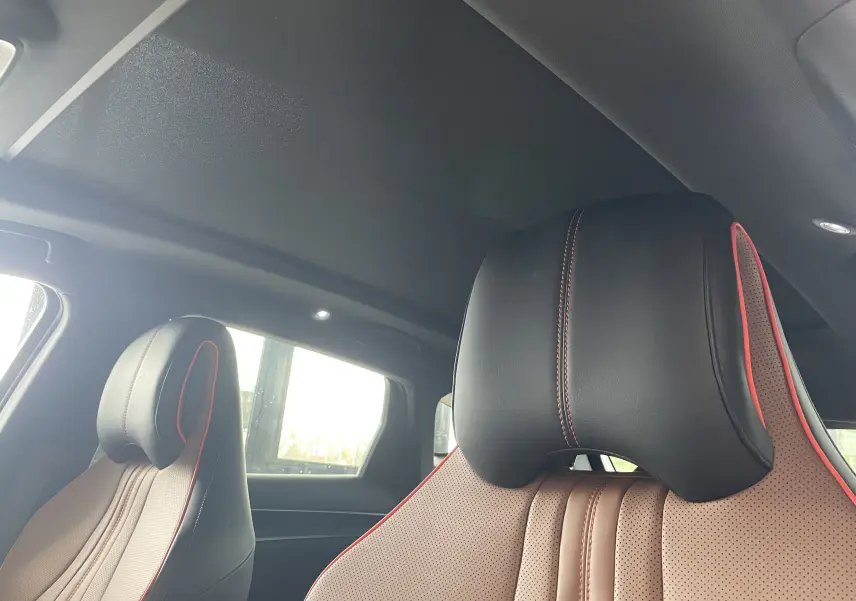 Gros plan sur les sièges avant en similicuir noir et marron avec surpiqûres rouges dans l'habitacle du BYD SEAL U.
