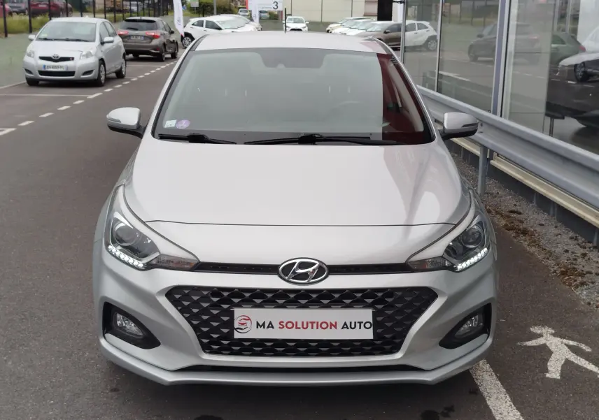 Vue frontale d'une Hyundai i20 2018 en Sleek Silver Métal avec calandre noire et feux LED allumés.