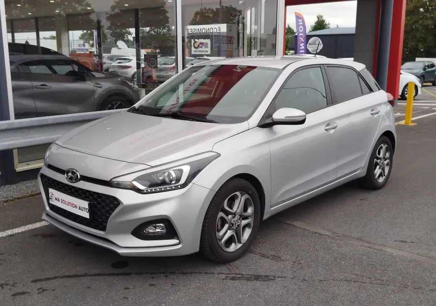 Vue 3/4 avant droite d'une Hyundai i20 2018 gris argent métallisé avec jantes alliage et calandre hexagonale noire.