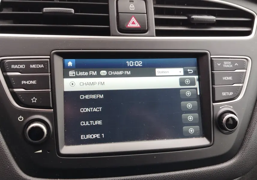 Vue rapprochée de l’écran multimédia central de la Hyundai i20 2018, affichant la liste des stations FM.