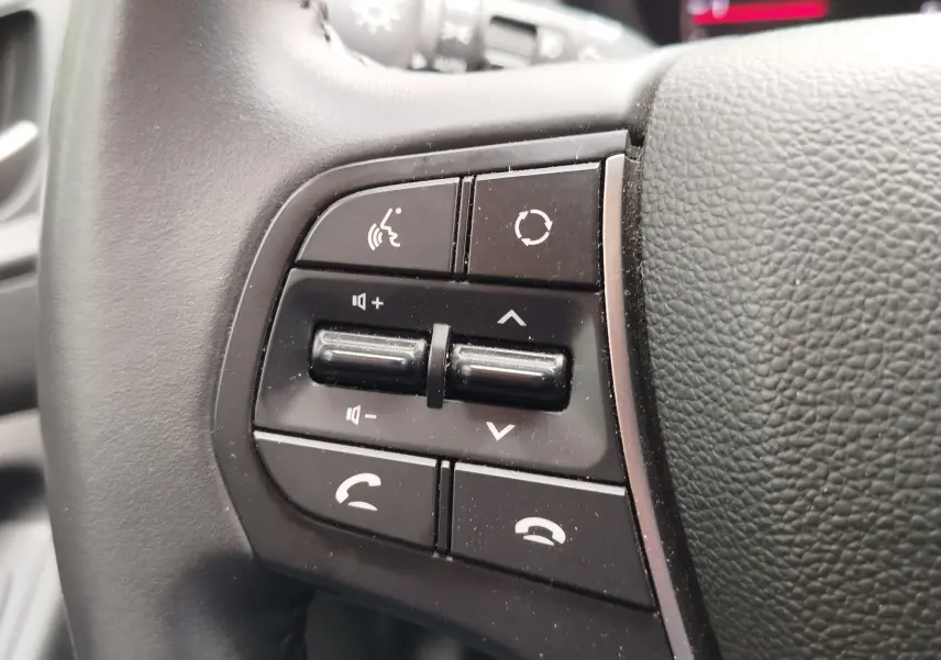Gros plan sur les commandes multifonctions noires à gauche du volant en cuir noir du Hyundai i20 Sleek Silver 2018.