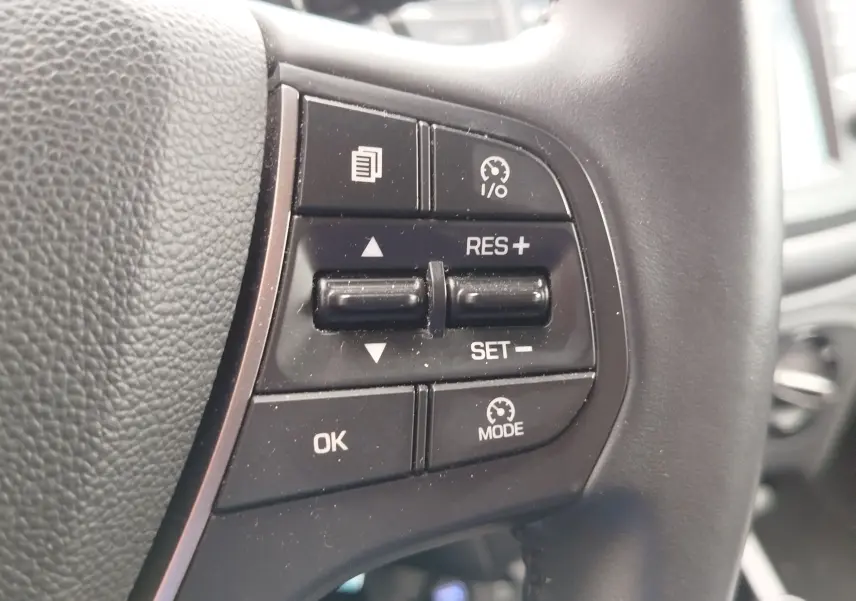 Gros plan sur les commandes de régulateur de vitesse au volant noir de la Hyundai i20 Sleek Silver 2018.