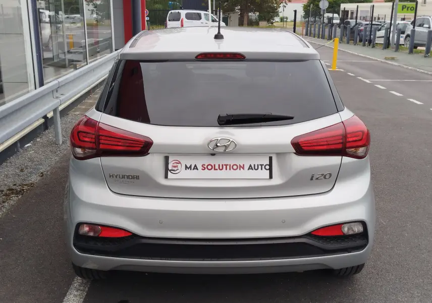 Vue arrière d'une Hyundai i20 2018 couleur Sleek Silver Métal avec feux rouges et lunette arrière teintée.