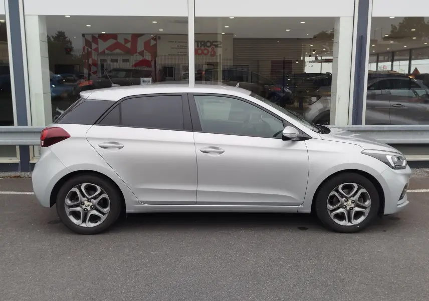 Vue latérale droite d'une Hyundai i20 2018 gris argenté avec vitres teintées et jantes alliage.
