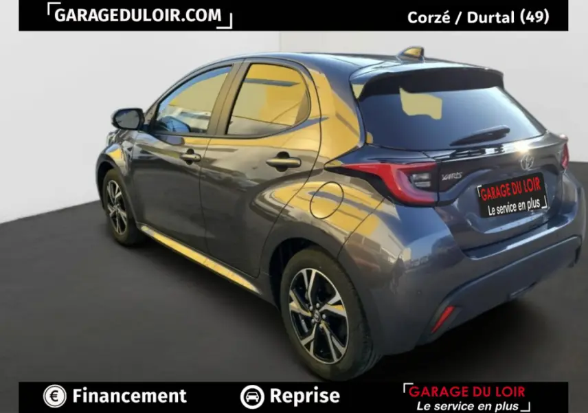 Vue 3/4 arrière droite d'une Toyota Yaris hybride 116h Design gris foncé avec jantes alliage et feux LED distinctifs.
