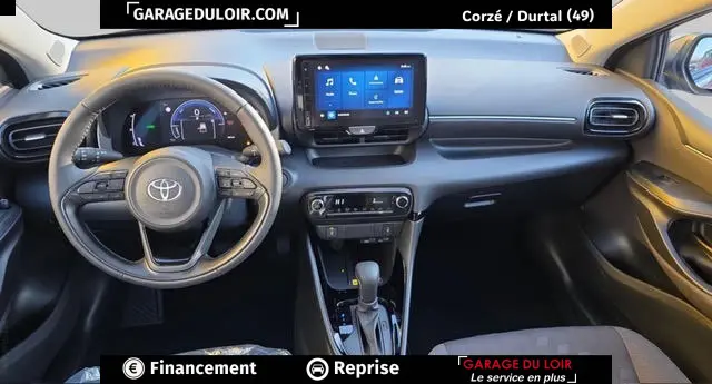 Vue intérieure avant de la Toyota Yaris Hybride 116h Design 2026 gris foncé, tableau de bord avec écran tactile central et volant multifonctions cuir.