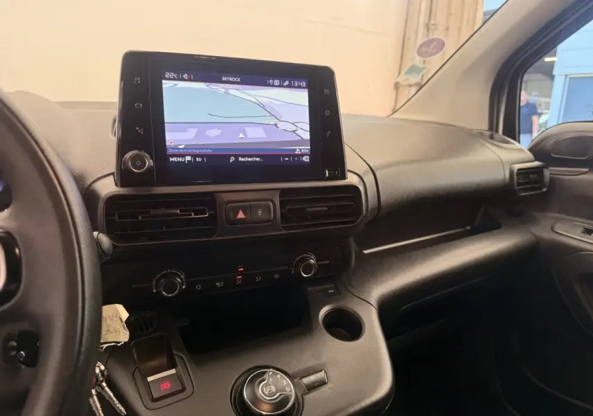 Vue intérieure côté conducteur du tableau de bord noir du Citroën Berlingo 2022 avec écran tactile et commande de boîte automatique.