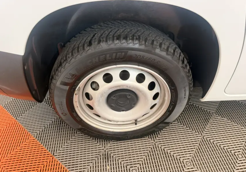 Gros plan sur la roue arrière droite du Citroën Berlingo blanc avec jante acier et pneu Michelin.