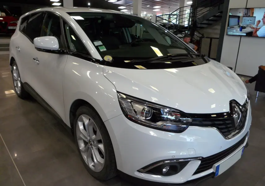 Renault Grand Scenic IV blanc Glacier en 3/4 avant droit, avec phares LED et calandre noire brillante.