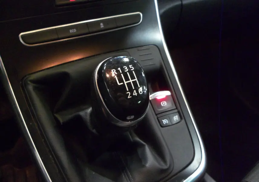 Le levier de vitesses manuel noir du Renault Grand Scenic IV Blue dCi 120 Business, entouré de commandes et éclairage intérieur.