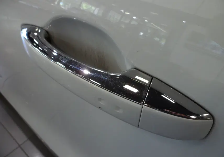 Poignée de porte chromée sur la portière blanche glacier d'un Renault Grand Scenic IV Blue dCi 120 CH BUSINESS 2019.