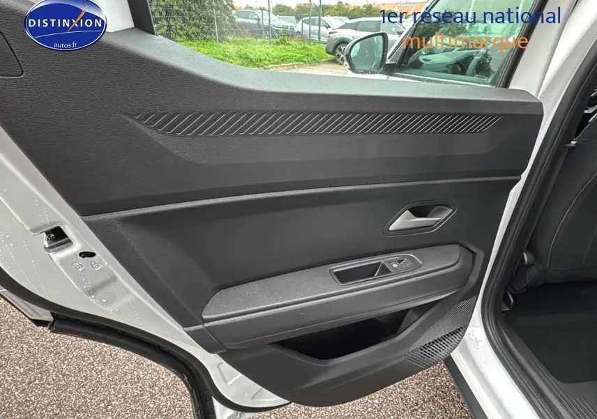 Porte arrière côté gauche ouverte du Dacia Duster blanc Arctic, montrant la garniture intérieure noire et la commande de vitre.