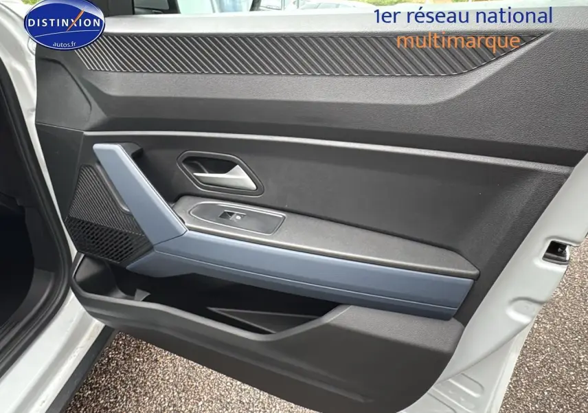 Intérieur côté gauche de la porte avant d'un Dacia Duster blanc Arctic, avec poignée argentée et accoudoir gris.