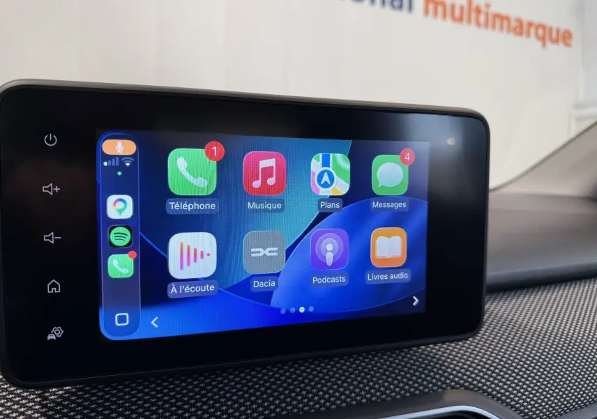 Écran tactile central de la Dacia Sandero 2025 affichant des applications connectées dans un intérieur moderne gris.