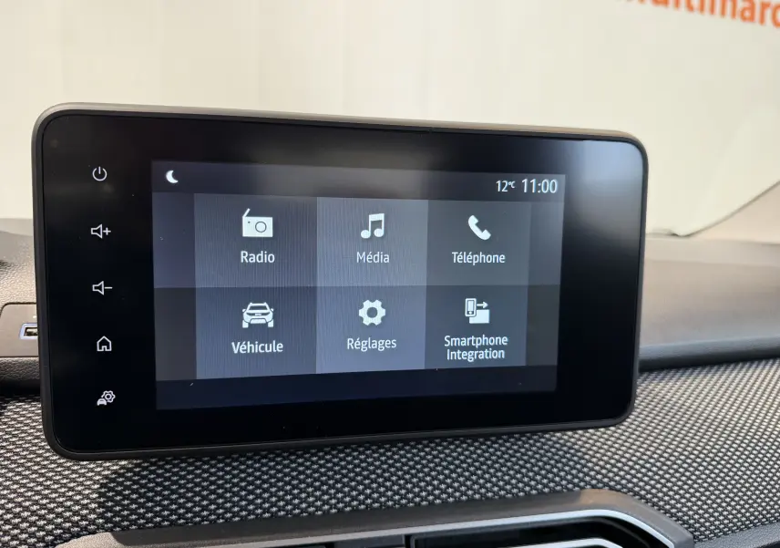 Écran tactile central du tableau de bord de la Dacia Sandero gris, affichant les options radio, média et téléphone.