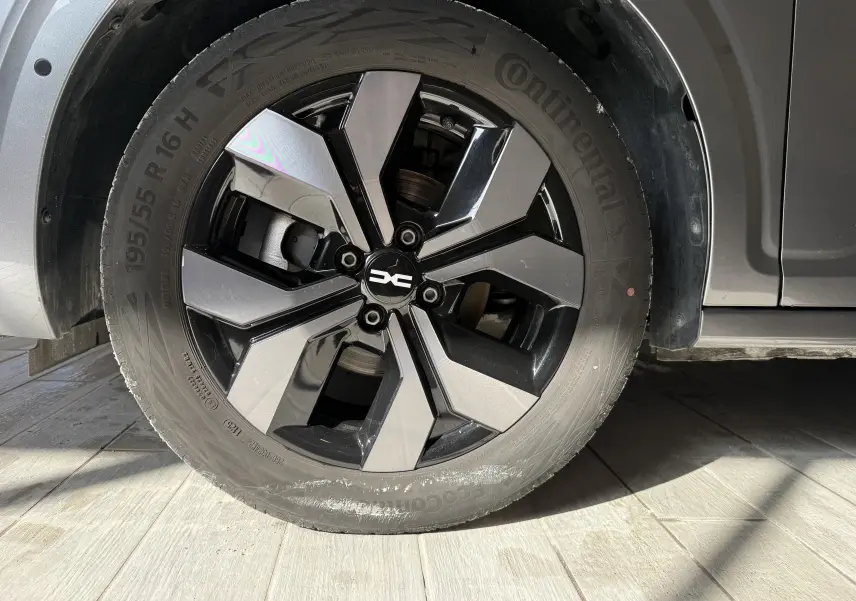 Gros plan sur la roue avant gauche gris métallisé de la Dacia Sandero 2025 avec jante alliage bicolore moderne.