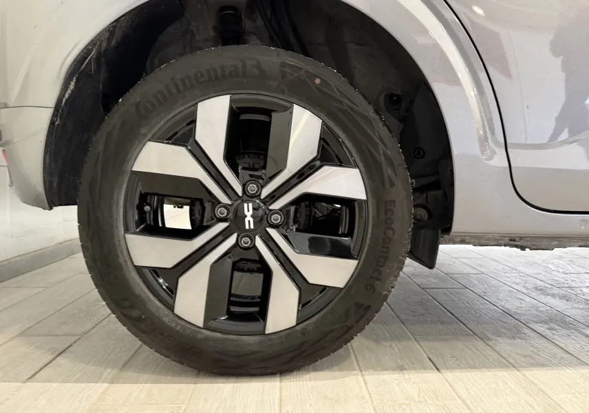 Gros plan sur la roue avant droite avec jante alliage bicolore du Dacia Sandero gris 2025, version 1.0 TCe 90ch Journey.