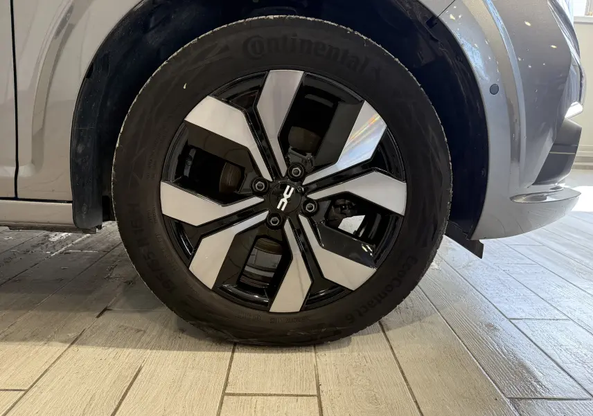 Gros plan sur la roue avant droite d'une Dacia Sandero gris 2025, jante alliage bicolore et pneu Continental.